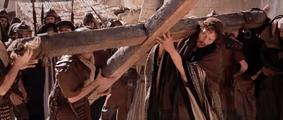 Szymon dźwiga krzyż Jezusa | Kadr z filmu „Pasja” Mela Gibsona