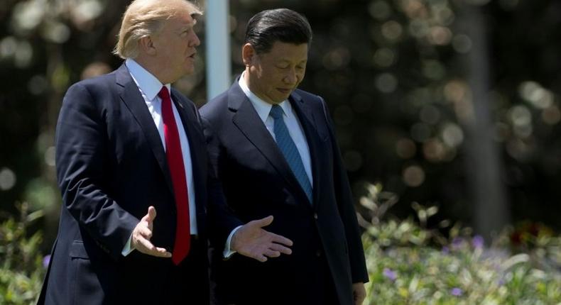 US President Donald Trump (L) and Chinese President Xi Jinping (R) walk together at the Mar-a-Lago estate in West Palm Beach, Florida, April 7, 2017
