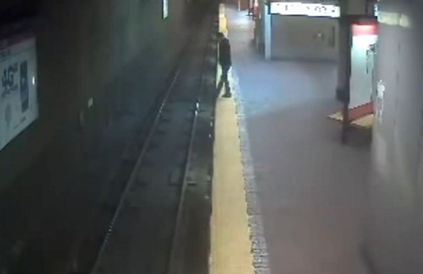 trenutak pre nego što će žena pasti na šine voza