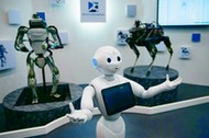 Humanoidalny robot Pepper, za nim stoją roboty Atlas i Spot