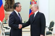 Prezydent Rosji Władimir Putin ściska dłoń dyrektora Biura Centralnej Komisji Spraw Zagranicznych Chin Wang Yi podczas spotkania na Kremlu. 23 lutego 2023 r.