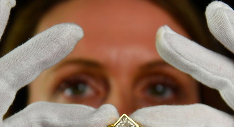 Anna Reynolds, curator for the Royal Collection, holds a 17th century gold and diamond signet ring belonging to the wife of Charles I, at the Queen's Gallery, in Buckingham Palace, London May 7, 2013. The earring forms part of the In Fine Style: The Art of Tudor and Stuart Fashion exhibition which will open on May 10tr