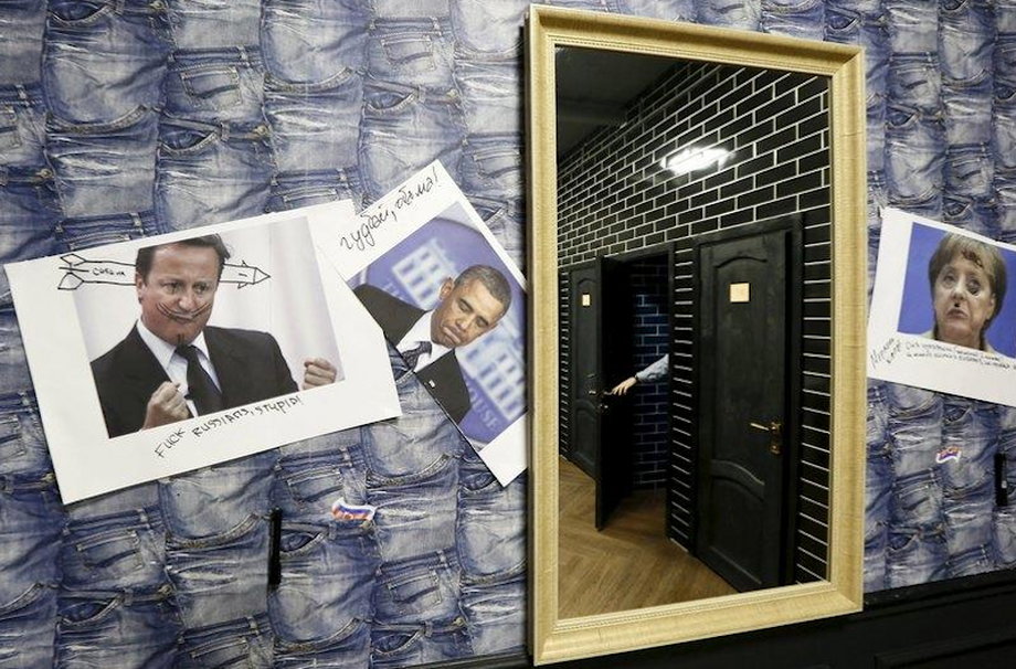 A visitor closes the toilet door as portraits of foreign leaders are seen on a wall at the "President Cafe" in Krasnoyarsk, Siberia, Russia, April 7, 2016.