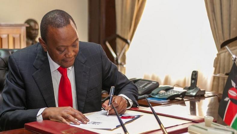 President Uhuru Kenyatta signing a bill in the past