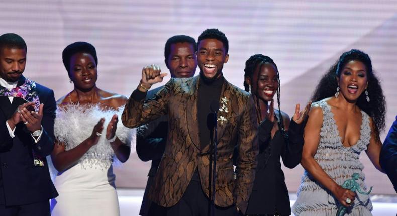 Chadwick Boseman (C) accepts the top SAG Award for Black Panther flanked by his castmates including Michael B. Jordan (L), Danai Gurira (C), Lupita Nyong'o (2R) and Angela Bassett (R)