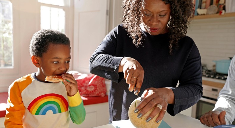 woman at home in kitchen cutting fruit