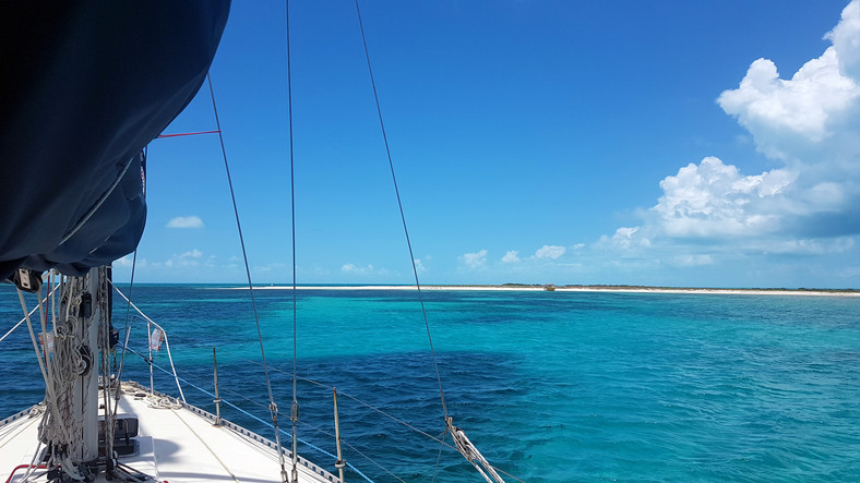 Turkusowe wody Bahamów z pokładu małej łódki żaglowej