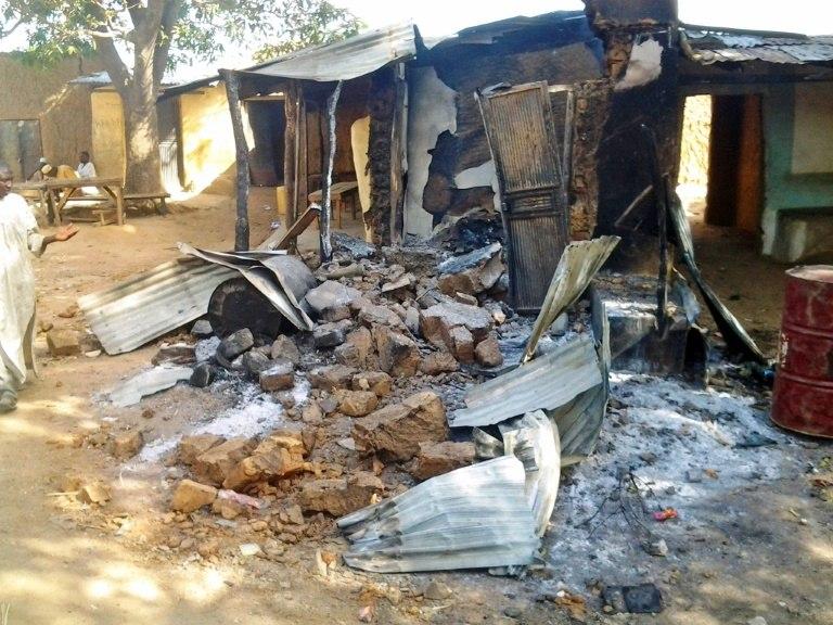 A resident inspects a burnt out house in Kizara village attacked by bandits who killed 48 people while early May saw dozens abducted in just two days on a road near the Zamfara state border 