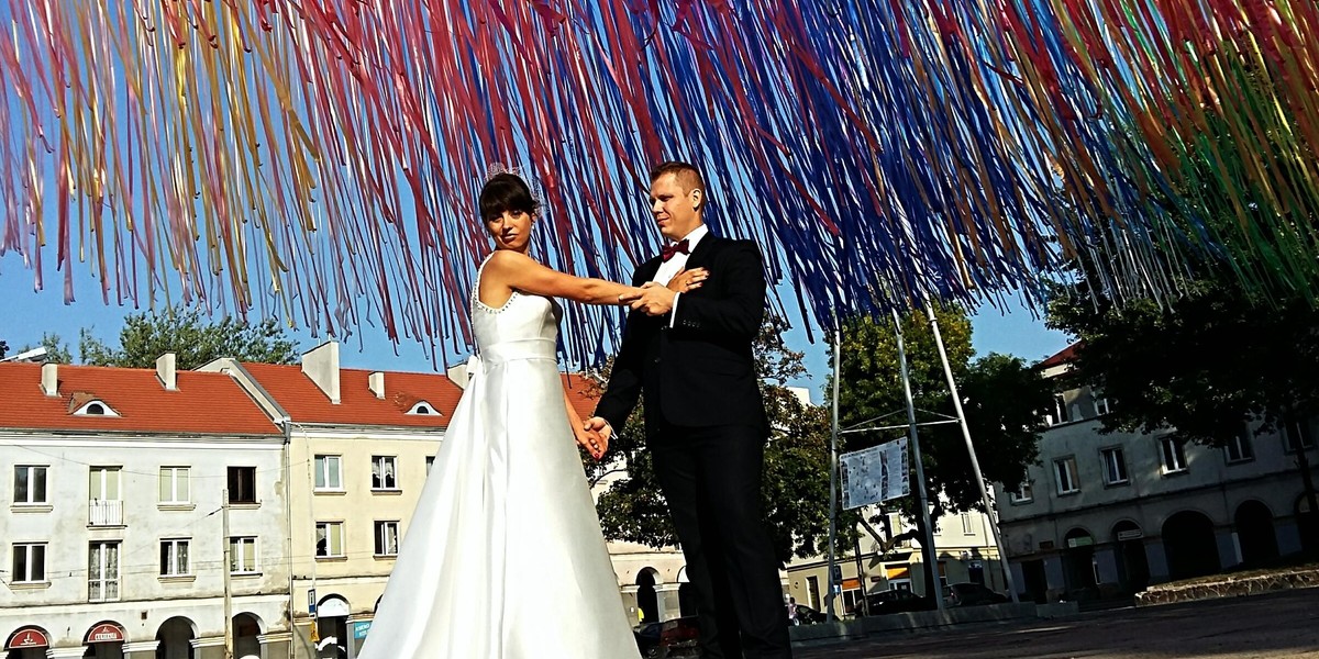 Ślubne zdjęcia pod wstążkami na Starym Rynku w Łodzi. Plener fotografii ślubnej pod instalacją Jerzego Janiszewskiego najpopularniejszy w Łodzi