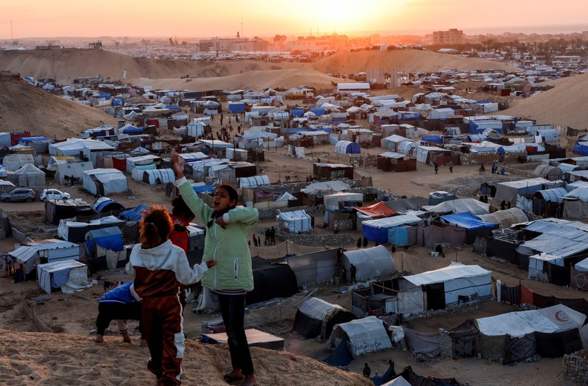 Raseljena palestinska deca na uzbrdici ispod koje je izbegličko šatorsko naselje | Foto: Reuters