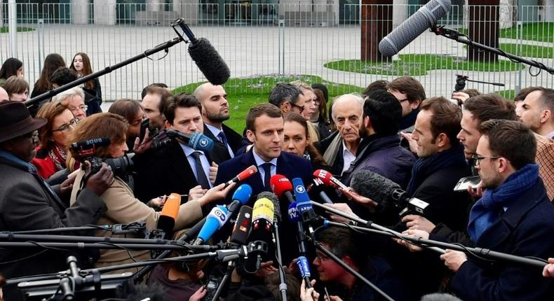 French presidential election candidate for the En Marche! movement Emmanuel Macron (C) speaks to journalists after a meeting with German Chancellor Angela Merkel in the Chancellery in Berlin on March 16, 2017