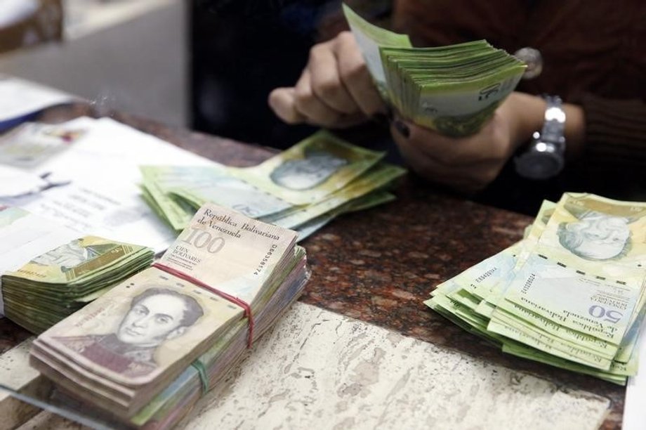 A cashier counts bolivars at money exchange in Caracas, February 24, 2015.