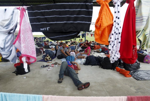 Cuban migrants rest at a basketball court as they wait boat to continue their journey north, in Puer