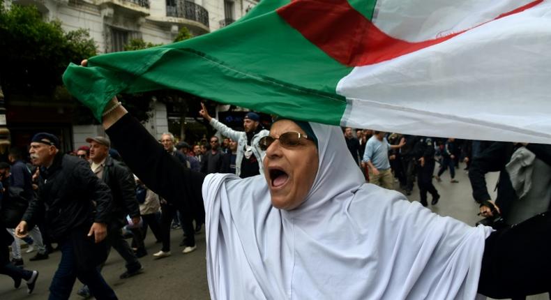 An Algerian woman waves a national flag during an  anti-government demonstration in the capital Algiers on March 14, 2020