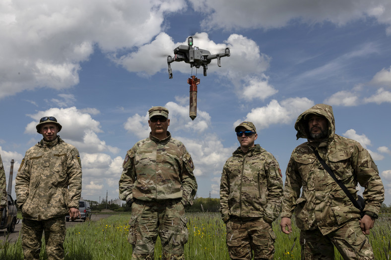 Ukraińscy żołnierze oraz dron z podczepionym ładunkiem wybuchowym