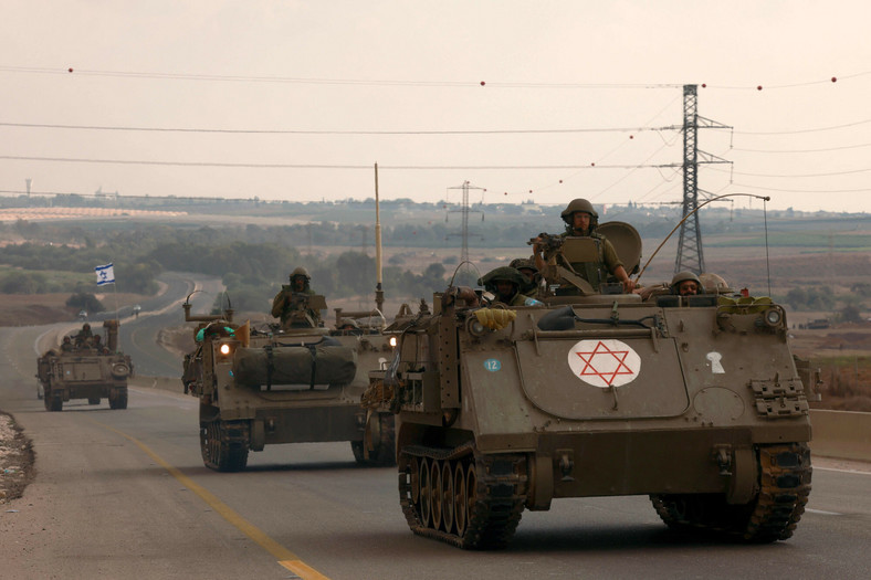 Izraelscy żołnierze jadą w pojazdach opancerzonych w kierunku granicy ze Strefą Gazy, 16 października 2023 r.