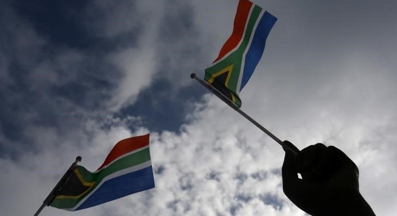 A hand is seen holding  a South African flag  in Pretoria, December 11, 2013.   REUTERS/Yannis Behrakis