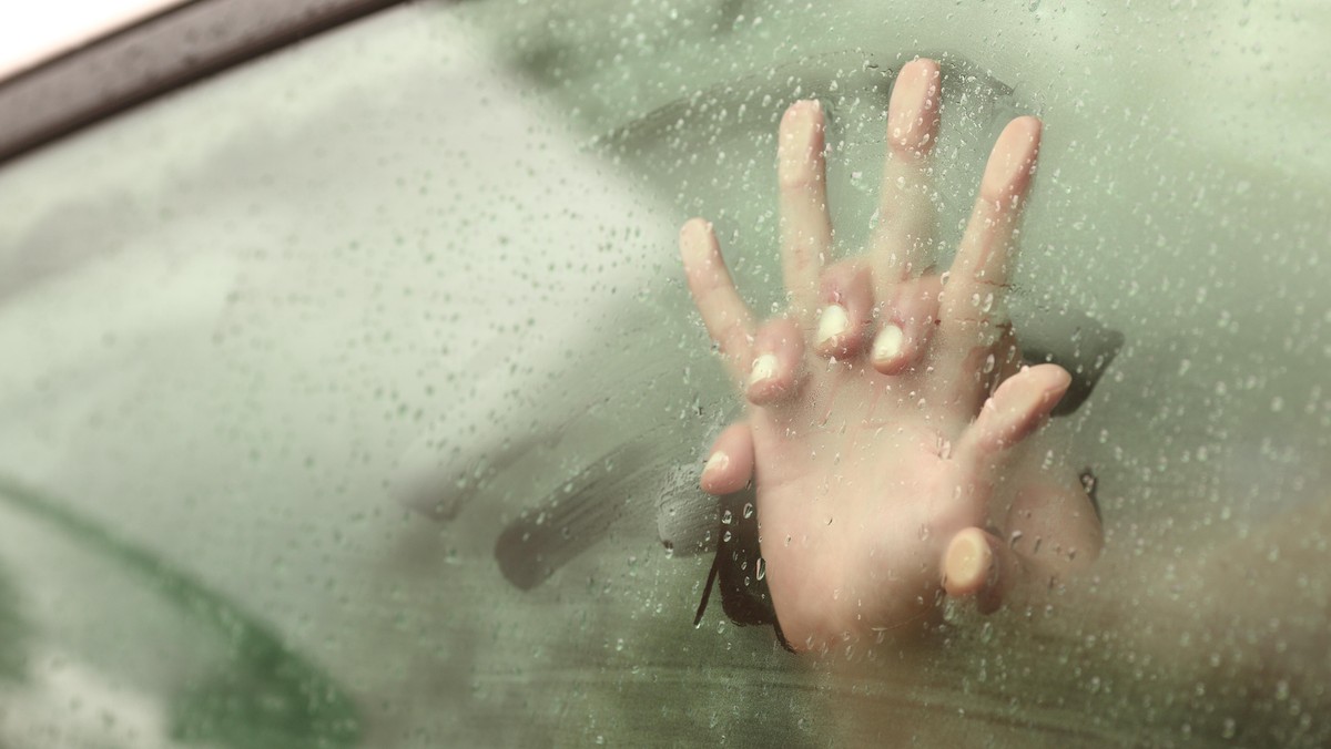 Couple holding hands having sex inside a car