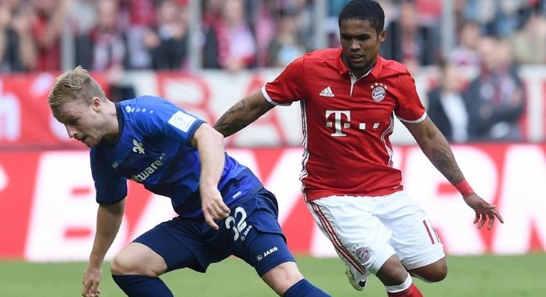 Darmstadt’s Fabian Holland (left) and Bayern Munich's Douglas Costa in action during a Bundesliga match in Munich, on May 6, 2017