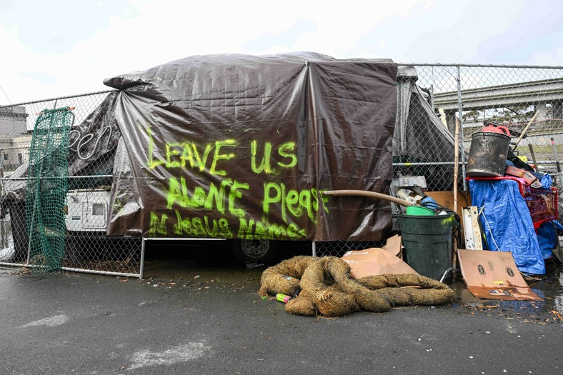 Obozowisko bezdomnych na ulicy w West Oakland w Kalifornii, napis głosi: "zostawcie nas samych"