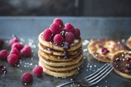 Vegan pancakes with chocolate sauce, raspberries and popped amaranth