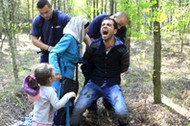 Hungarian policemen detain a Syrian migrant family after they entered Hungary at the border with Ser