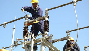 A Kenya Power employee working on a power line