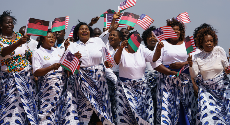 women sing and wave flags in Lilongwe