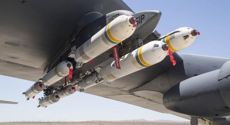 A B-52 Stratofortress assigned to the 419th Flight Test Squadron with eight PDU-5/B leaflet bombs under the left wing.