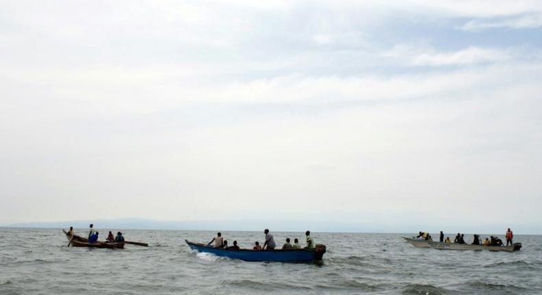 Uganda Police divers and local fishermen search for victims of a boat disaster on Lake Albert near Kitebere on March 23, 2013