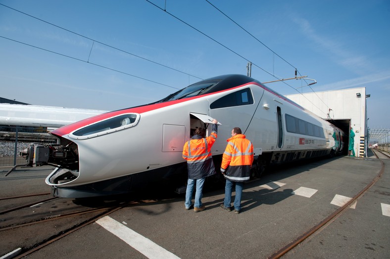 Pracownicy dokonują przeglądu szwajcarskiej szybkiej kolei Pendolino SBB AG we włoskiej fabryce Alstomu w Savigliano. Alstom SA, drugi największy producent szybkich pociągów na świecie, wyprodukował 2/3 wszystkich szybkich pociągów globu. Fot. Bloomberg.