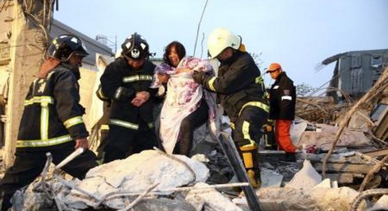 Rescue personnel help a victim at a damaged building after an earthquake in Tainan, southern Taiwan, February 6, 2016.
