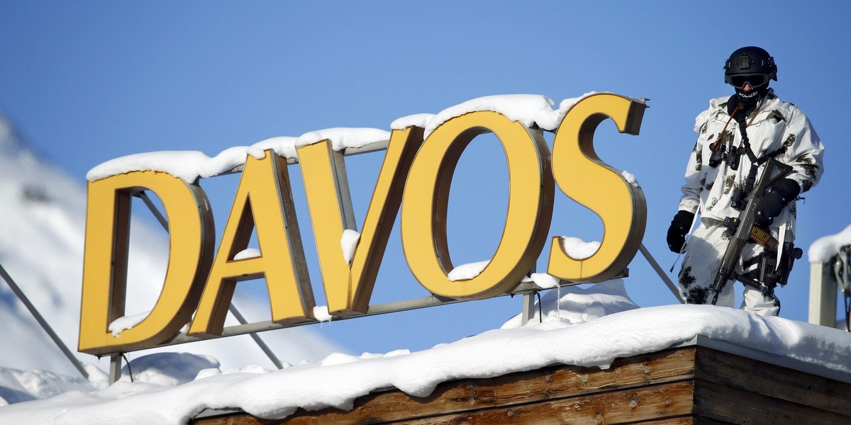 Swiss special police officer observes the area from atop the roof of a building during the annual meeting of the WEF in Davos