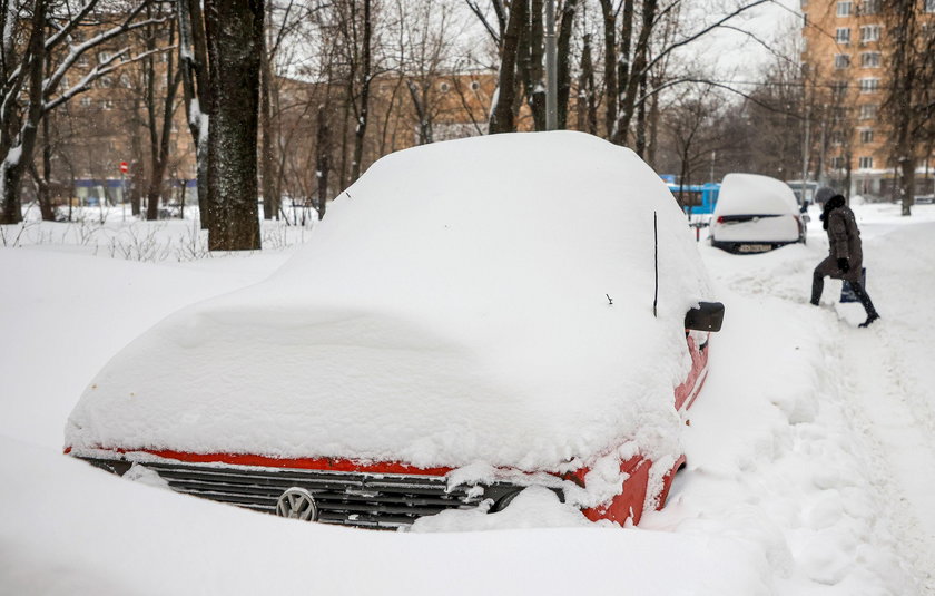 Workers remove snow in a street in Moscow