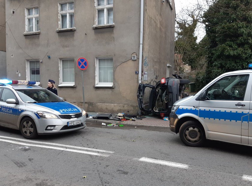 Kierujący i kobieta zostali w aucie, które stało na boku oparte dachem o kamienicę. 