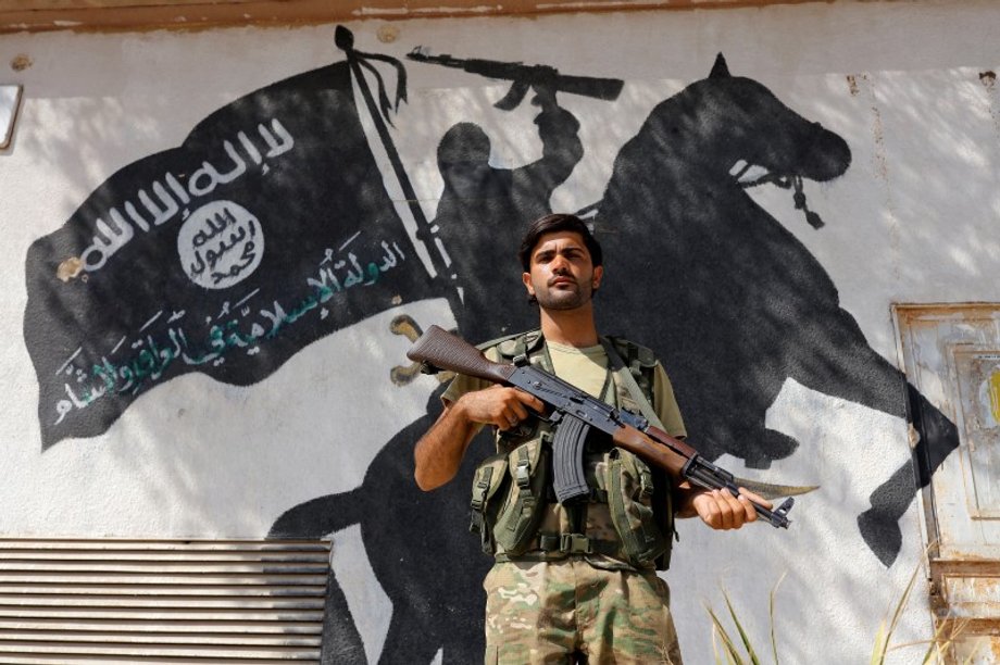 A member of the Turkish-backed Free Syrian Army in front of a building in the border town of Jarablus.