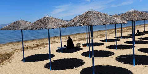 A woman sits at Peraia beach as Greece begins a gradual easing of the nationwide lockdown due to the spread of the coronavirus disease (COVID 19), in Thessaloniki, Greece, on May 5..JPG