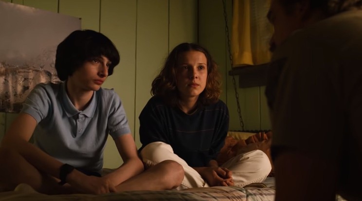 Mike (Finn Wolfhard) és Tizi (Millie Bobby Brown) épp fejmosást kapnak Hawkins marcona seriffjétől, Hoppertől (David Harbour) / Fotó: Netflix