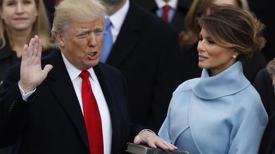 Donald Trump takes the oath of office as his wife Melania holds a bible during his inauguration as the 45th president of the United States on the West front of the U.S. Capitol in Washington