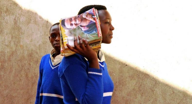 A refugee student holds magazines at the Kiziba camp in western Rwanda