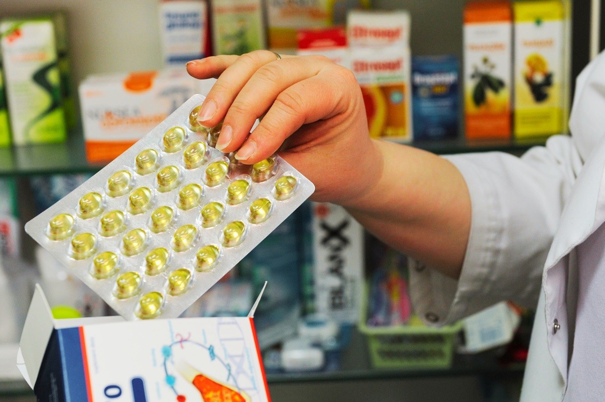 Farmaceutka trzyma blister z lekami – nowa lista leków bez refundacji RDTL, NFZ 2025