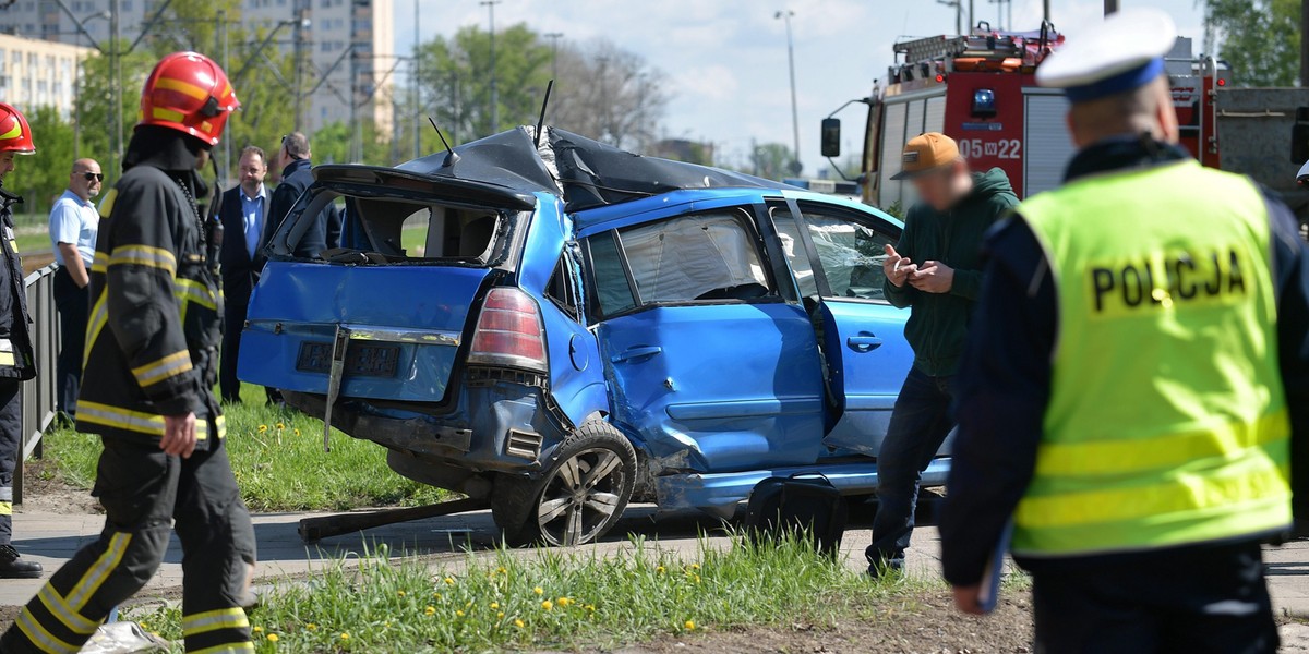 Samochód zaklinowany pomiędzy tramwajem a słupem. W środku ciężarna kobieta i dziecko