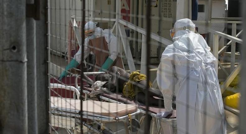 Health workers push a wheeled stretcher holding a newly admitted Ebola patient in a file photo. REUTERS/Baz Ratner