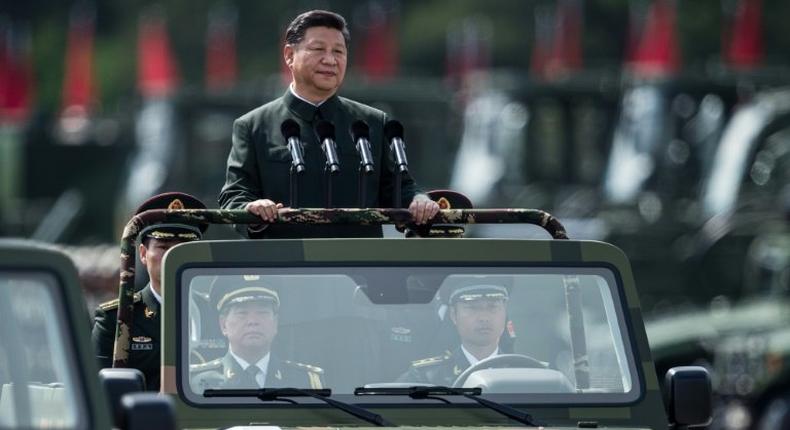 China's President Xi Jinping wore a Mao suit as he was driven in an open-top jeep past serried ranks of the People's Liberation Army, in a rare show of force in Hong Kong