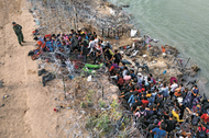 MONITORING Asylum seekers supervised by border control agents who cut wire to allow entry to Texas for processing.