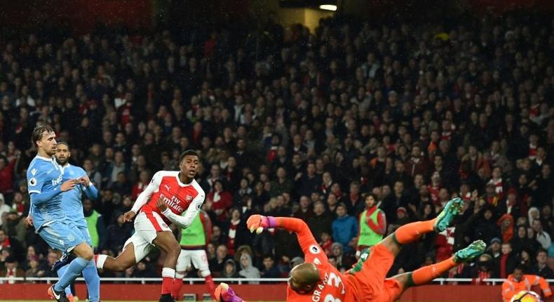 Arsenal's Alex Iwobi (3L) shoots and scores past Stoke City's goalkeeper Lee Grant at the Emirates Stadium in London