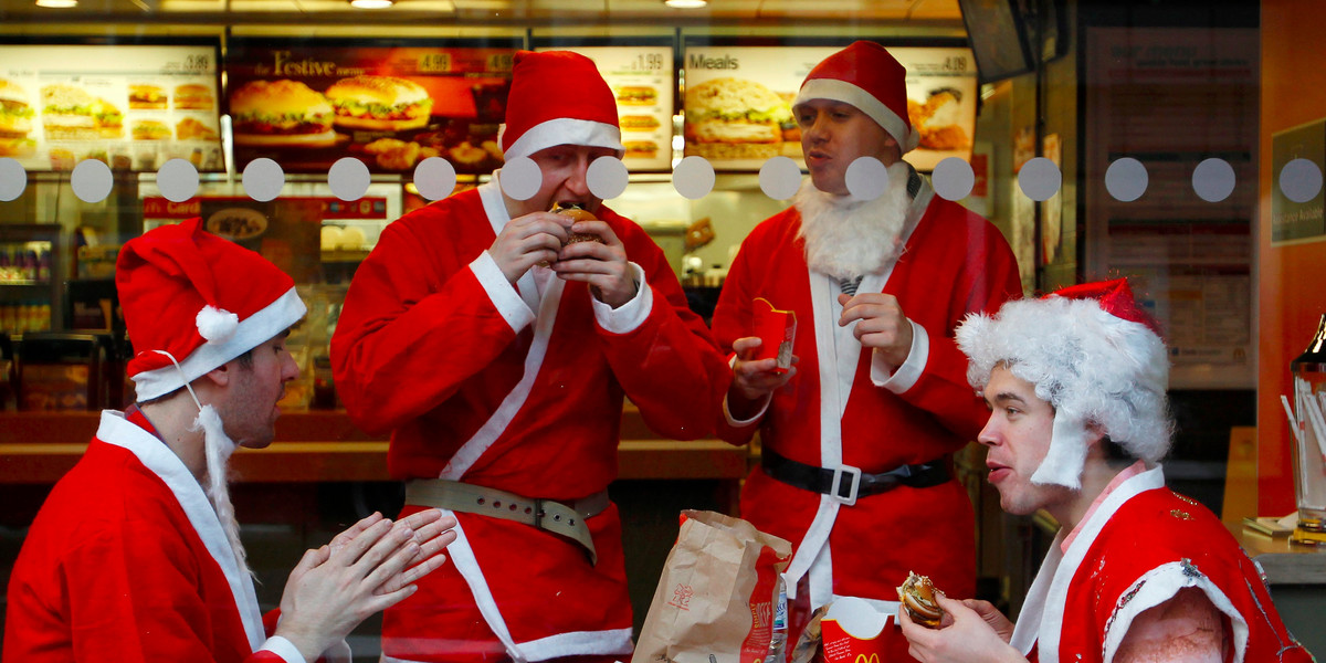 Men wearing Father Christmas outfits eat in a fast food restaurant in central London December 12, 2009.