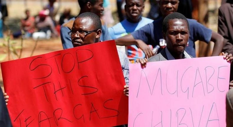 Opposition party supporters hold placards during a court appearance of those arrested following Friday's protest march, in Harare, Zimbabwe, August 29, 2016. 