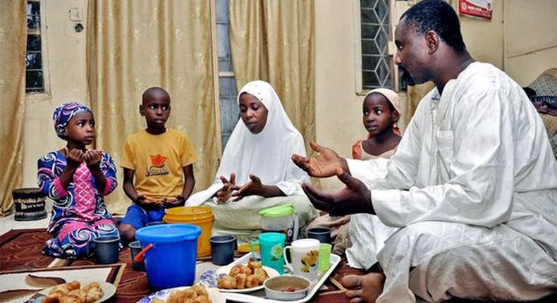 A father and his family sit around a meal for Iftar during Ramathan