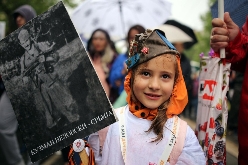 Devojčica koja nosi fotografiju svog pretka